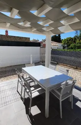 a white table and chairs on a patio at Beach View Vela House in Albufeira