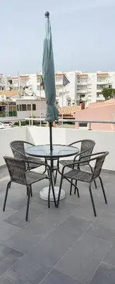 a table and chairs with an umbrella on a patio at Beach View Vela House in Albufeira