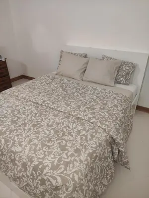 a bed with a gray and white comforter and pillows at Vilamoura Marina, Av Tivoli in Vilamoura