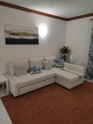 a white living room with a white couch and a painting at Vilamoura Marina, Av Tivoli in Vilamoura