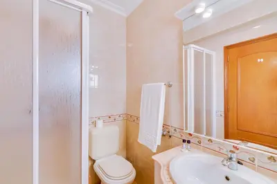a bathroom with a toilet and a sink and a mirror at AL - Colina Beach Holidays in Quarteira