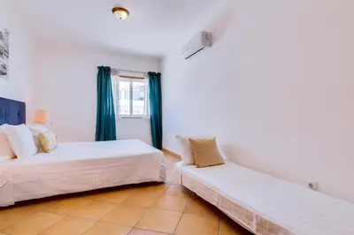 a bedroom with two beds and a window at AL - Colina Beach Holidays in Quarteira