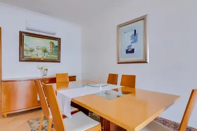 a dining room with a wooden table and chairs at AL - Colina Beach Holidays in Quarteira