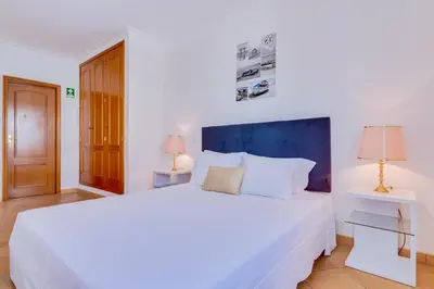 a bedroom with a large white bed and two lamps at AL - Colina Beach Holidays in Quarteira