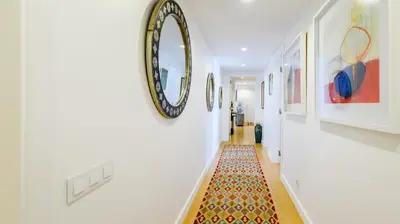 a hallway with a rug and a mirror on the wall at Marina Real - Sea View by HD PROPERTIES in Vilamoura