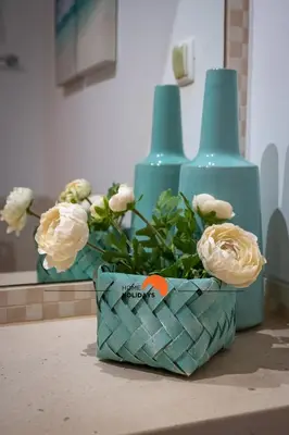 a basket of flowers sitting on a counter with two blue vases at #093 Vista das Ondas by Home Holidays in Albufeira