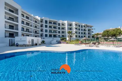 a swimming pool in front of a large building at #093 Vista das Ondas by Home Holidays in Albufeira