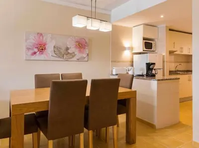 a kitchen and dining room with a wooden table and chairs at Albufeira Sol Villas I by Stay ici Algarve Holiday Rental in Albufeira