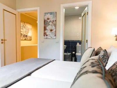 a bedroom with a white bed and a bathroom at Albufeira Sol Villas I by Stay ici Algarve Holiday Rental in Albufeira