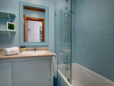 a bathroom with a sink and a shower and a mirror at Akisol Olhos de Água Ocean in Albufeira