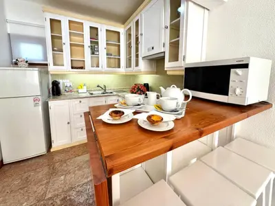 a kitchen with a wooden table with two plates of food at Akisol Olhos de Água Ocean in Albufeira