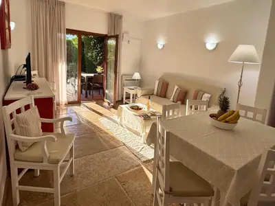 a kitchen and living room with a table and chairs at Akisol Olhos de Água Ocean in Albufeira