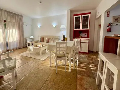 a kitchen and living room with a table and chairs at Akisol Olhos de Água Ocean in Albufeira