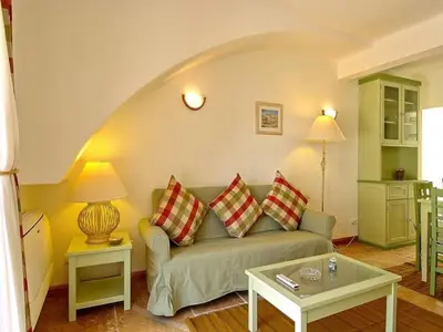 a living room with a couch and a table at Akisol Olhos de Água Ocean in Albufeira