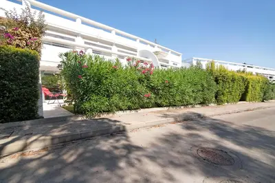 a building with a row of bushes and flowers at Large apartment in Vale do Lobo in Almancil