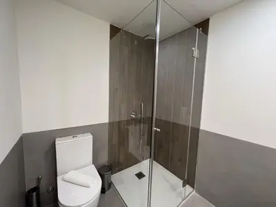 a bathroom with a toilet and a glass shower at Faro Design 1 by Homing in Faro