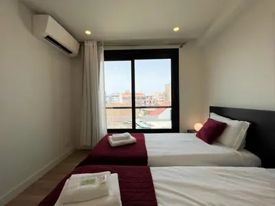 a bedroom with two beds and a large window at Faro Design 3 by Homing in Faro