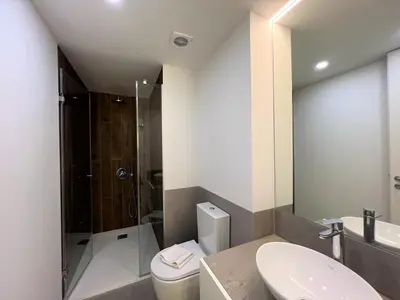 a bathroom with a toilet and a shower and a sink at Faro Design 4 by Homing in Faro