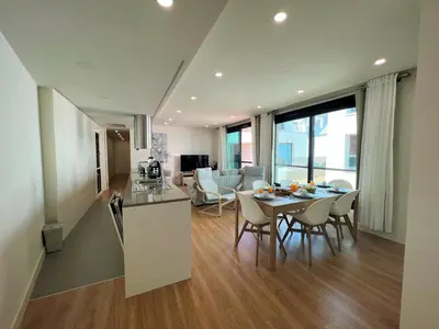 a kitchen and living room with a table and chairs at Faro Design 4 by Homing in Faro