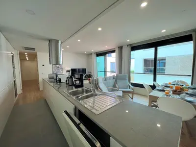 a kitchen with a sink and a living room at Faro Design 4 by Homing in Faro
