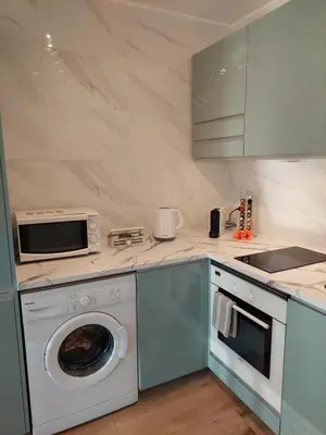 a kitchen with a washing machine and a microwave at Sun&Sea in Quarteira