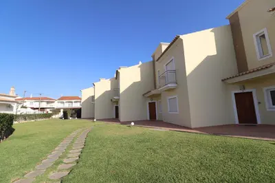 a row of houses with a grass yard at 3-Bed Townhouse with pool in Albufeira Balaia in Albufeira