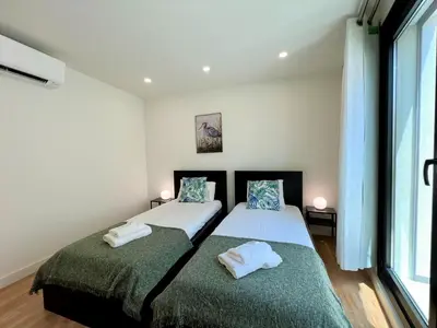 two twin beds in a room with a window at Faro Design 6 by Homing in Faro