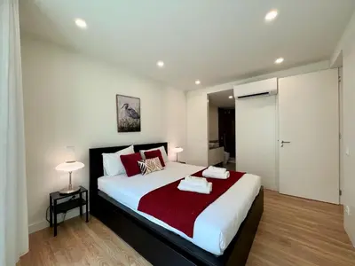 a bedroom with a large bed with a red blanket at Faro Design 6 by Homing in Faro