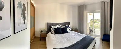 a bedroom with a bed with black and white pillows at Albufeira Deluxe Residence With Pool by Homing in Albufeira