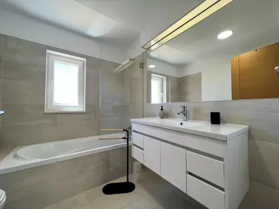 a bathroom with a tub and a sink and a bath tub at Albufeira Deluxe Residence With Pool by Homing in Albufeira