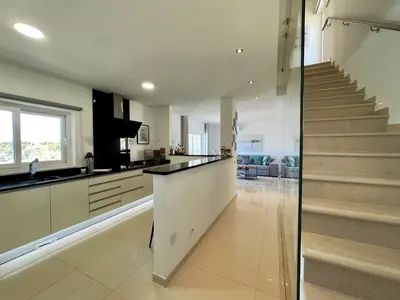 a kitchen with a staircase leading up to a living room at Albufeira Deluxe Residence With Pool by Homing in Albufeira