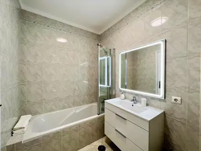 a bathroom with a tub and a sink and a bath tub at Quarteira Panoramic View by Homing in Quarteira