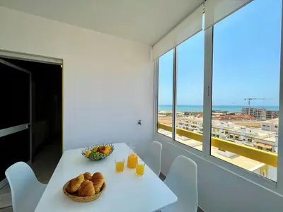a white table with a bowl of bread and orange juice at Quarteira Panoramic View by Homing in Quarteira