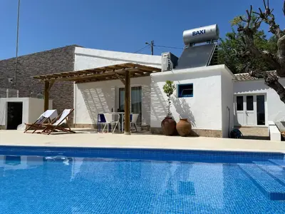 a swimming pool in front of a house at Casa Pedra São Romão in São Brás de Alportel