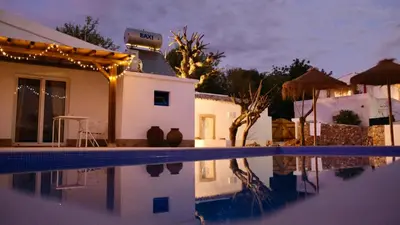 a villa with a swimming pool at night at Casa Pedra São Romão in São Brás de Alportel