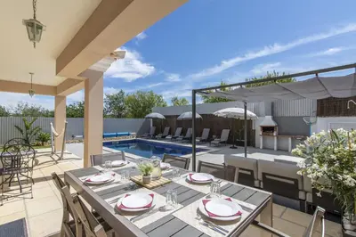 a patio with a table and chairs and a pool at Villa Maya in Almancil