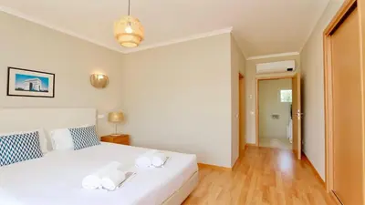 a bedroom with a white bed with two towels on it at Villa Bolivia-CleverDetails in Vilamoura