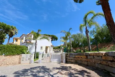 a white fence in front of a house with palm trees at Villa Bolivia-CleverDetails in Vilamoura