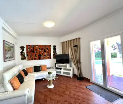 a living room with a white couch and a tv at Vila Rose - Private Pool by HD PROPERTIES in Vilamoura