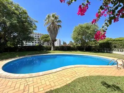 a swimming pool in a yard with a palm tree at Vila Rose - Private Pool by HD PROPERTIES in Vilamoura
