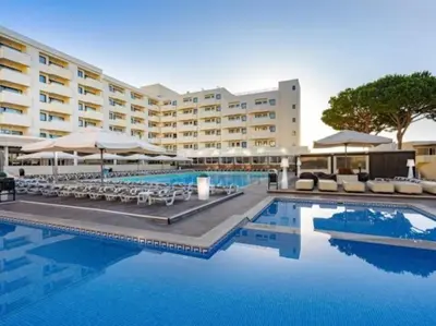 a hotel with a swimming pool with chairs and umbrellas at Albufeira Sol Villas III by Stay ici Algarve Holiday Rental in Albufeira