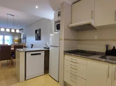 a kitchen with a white refrigerator and a sink at Albufeira Sol Villas III by Stay ici Algarve Holiday Rental in Albufeira