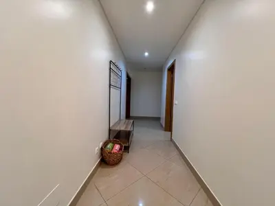 a hallway with a bench next to a wall at Mar e Sol by - T3 , wi-fi e estacionamento in Quarteira