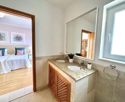 a bathroom with a sink and a mirror and a bed at Victoria I - Vasco da Gama by HD PROPERTIES in Vilamoura