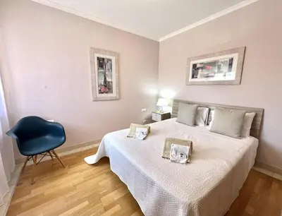 a bedroom with a bed and a blue chair at Victoria I - Vasco da Gama by HD PROPERTIES in Vilamoura