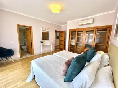 a bedroom with a bed with pillows and a couch at Victoria I - Vasco da Gama by HD PROPERTIES in Vilamoura