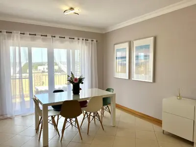 a dining room with a table and chairs and a window at Victoria I - Vasco da Gama by HD PROPERTIES in Vilamoura