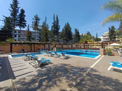 a swimming pool with lounge chairs next to a building at Blue & Yellow Penthouse with Terrace at Balaia Mar in Albufeira