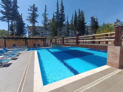 a swimming pool with lounge chairs next to a building at Blue & Yellow Penthouse with Terrace at Balaia Mar in Albufeira
