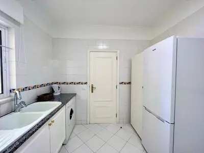 a white kitchen with a sink and a refrigerator at Vilamoura Central 2 With Pool by Homing in Vilamoura